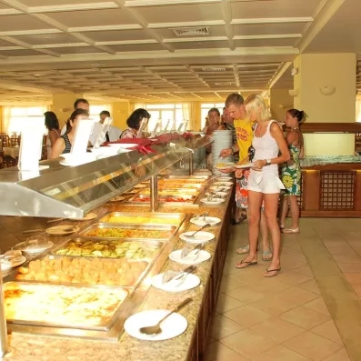 Clients choisissant leurs repas au grand buffet convivial du restaurant principal de l'hôtel Zephir Djerba.