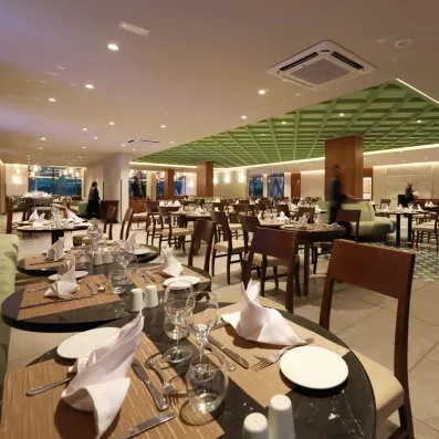restaurant de l'hôtel avec chaises beige et tables dressées