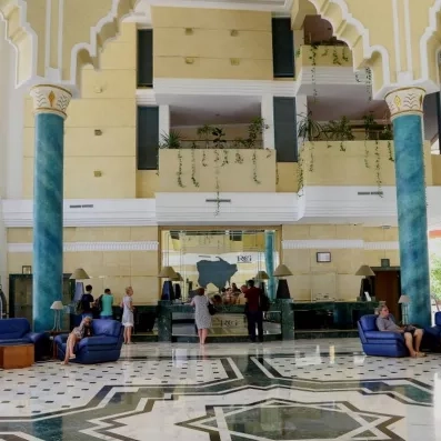 Hall d'entrée monumental avec colonnes bleues et architecture orientale raffinée au Royal Garden Palace à Djerba.