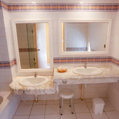 Salle de bain lumineuse avec double vasque en marbre et carrelage oriental typique de Djerba