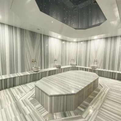 Un bain turc traditionnel luxueux entièrement revêtu de marbre gris et blanc.