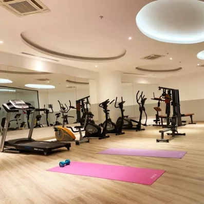 Un centre de remise en forme moderne et bien équipé avec des tapis de course, des vélos et des tapis de yoga.