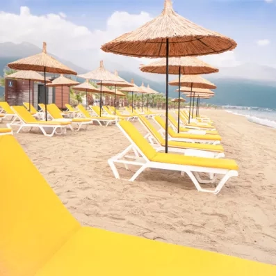 La plage privée de l'hôtel est bordée de transats sous des parasols en paille face à la mer.