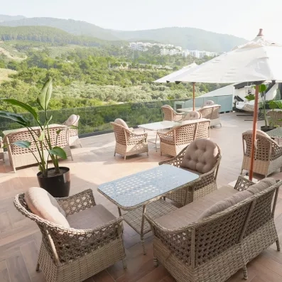 Un gros plan sur le mobilier de jardin de la terrasse, avec la vue imprenable sur le paysage verdoyant.