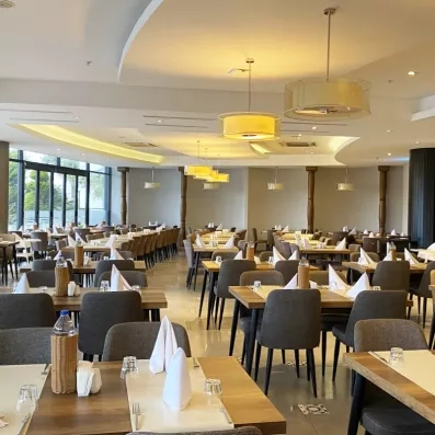 Une vaste salle de restaurant intérieure soigneusement dressée, dans un cadre raffiné.