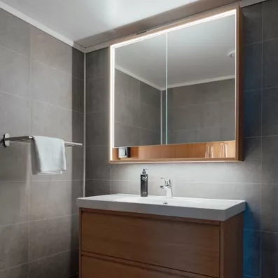 Salle de bain moderne et épurée avec miroir lumineux, équipement de standing pour votre voyage en Suède.