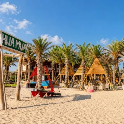 Espace détente en bord de plage et structures en bois à l'hôtel Welcome Meridiana Djerba