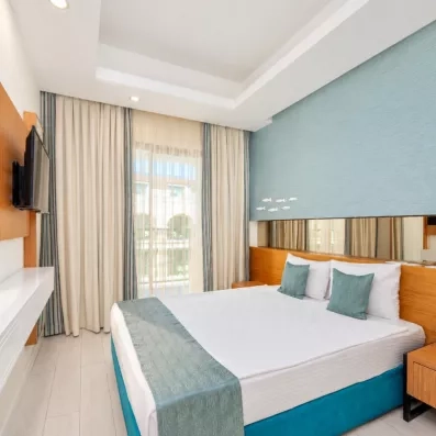 chambre avec un lit double et coussin turquoise