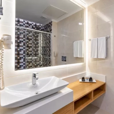 salle de bain en blanc et en bois avec lavabo et miroir
