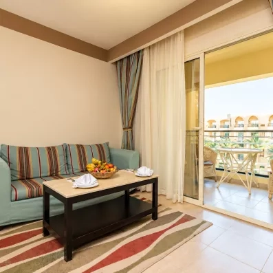 Coin salon d'une chambre avec canapé et balcon privé à l'hôtel El Karma Aqua Beach Resort à Hurghada.