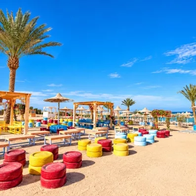 Espace détente coloré sur le sable à la plage de l'hôtel El Karma Aqua Beach Resort à Hurghada.