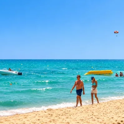 couple sur la plage qui marche au bord de l'eau bleu