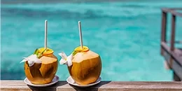 Noix de coco en cocktail avec la mer turquoise derrière